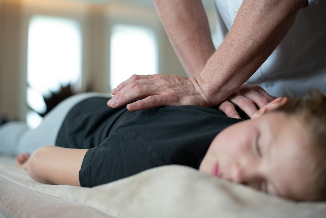 Hands giving a back adjustment on a treatment table.