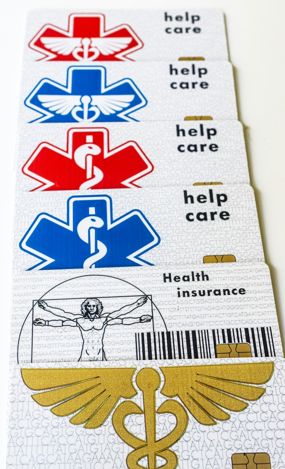 Five white health insurance cards with medical symbols stacked diagonally.